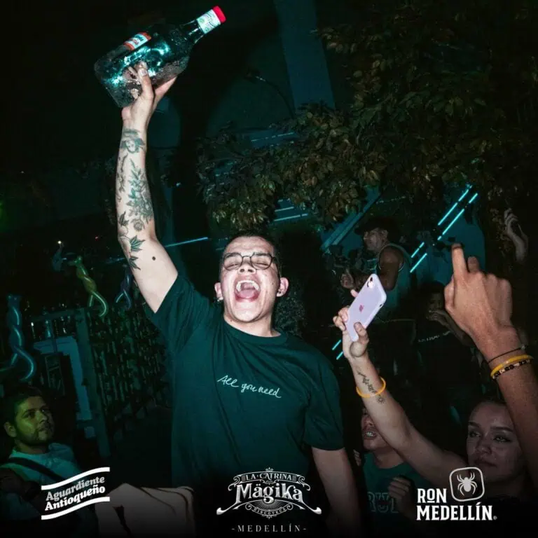 Anstoßen bei einer ausgelassenen Party in einem Nachtclub in Medellín, Feiern und Freude bei einem gesellschaftlichen Ereignis mit festlicher Atmosphäre und Live-Musik.