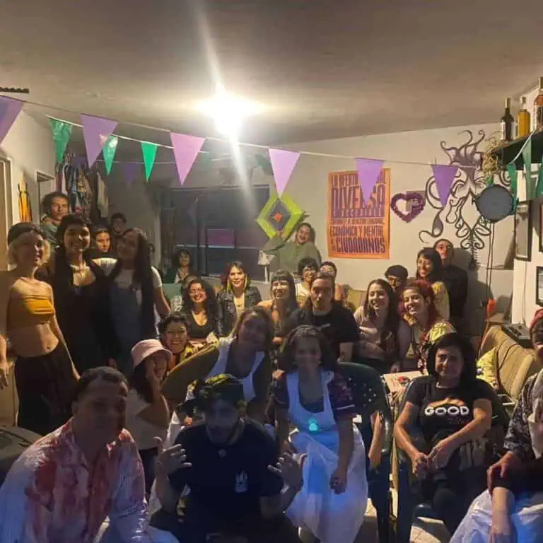 Un événement social amusant avec un groupe de personnes dans une ambiance festive, des décorations colorées, des bannières et des activités culturelles dans un espace communautaire.