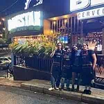 和朋友们在一家氛围热闹的摇滚酒吧享受夜晚时光。一群身着制服的调酒师在一家提供精酿啤酒、现场音乐和热情好客氛围的酒吧里工作。