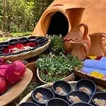 Haut : Ambiance spa temazcal traditionnel avec céramiques, fleurs et produits naturels pour une cérémonie de bien-être ancestrale lors d'un festival culturel.