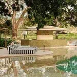 Espreguiçadeiras relaxantes junto à piscina em um ambiente natural, ideais para eventos e festas em meio à natureza, com sombra de árvores e uma atmosfera tranquila, perfeitas para aproveitar o dia.