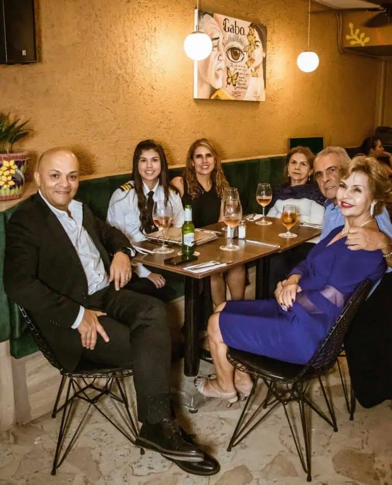 Enjoy dinner at a restaurant with elegantly dressed guests, toasting with rosé wine in a sophisticated and cozy atmosphere, ideal for events and social gatherings in Colombia.