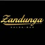 Zandunga Salsa Bar 标志，黑色背景上以金色字母呈现，描绘了城市中的一家莎莎酒吧，非常适合莎莎舞和酒吧活动及聚会，宣传氛围和现场音乐。