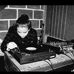 在室内场地举行的现场音乐活动中，DJ 进行混音表演。