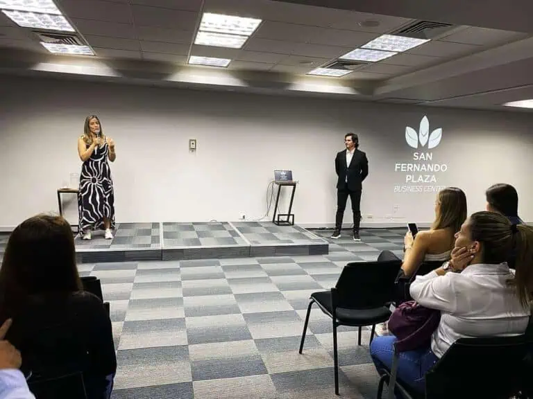 Présentation au centre d'événements San Fernando Plaza, avec un public écoutant une conférence sur l'organisation et la gestion d'événements d'entreprise à Carthagène, en Colombie, dans un espace moderne et professionnel.