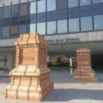 Alt: 位于波哥大共和国银行入口处的木结构建筑，采用现代设计和乡村建筑元素。