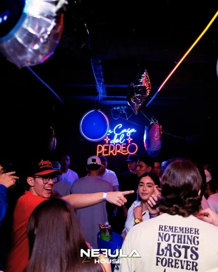 Celebration at a bar with balloon decorations and neon lights in a festive atmosphere, promoting events and entertainment.