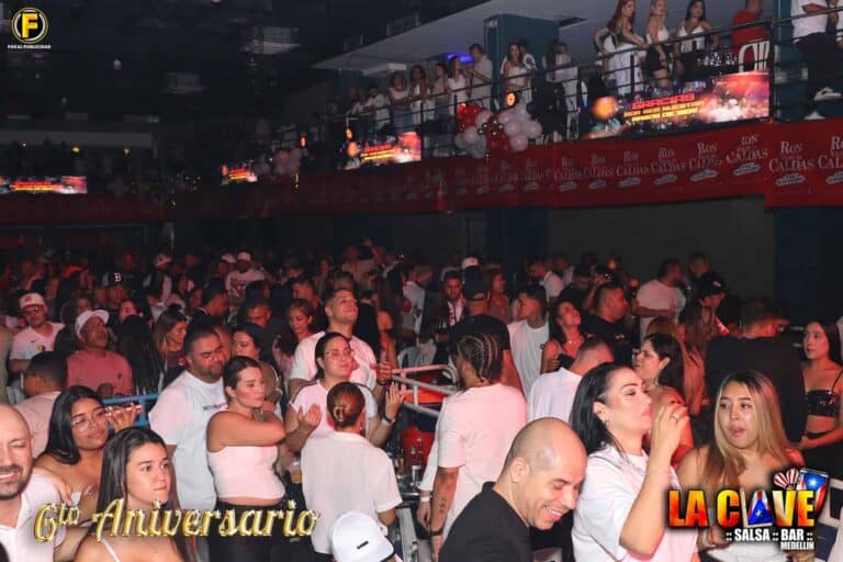 Celebración del 6º aniversario con una multitud disfrutando en un ambiente festivo en La Clave Medellín. La fiesta incluye música, baile y buena compañía en un evento especial para los asistentes.