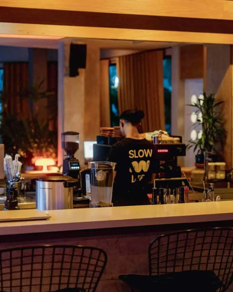 Ein Barista bereitet bei einer Veranstaltung in einem modernen und einladenden Ambiente Kaffee zu, mit warmem Dekor und zeitgenössischen Stilelementen.