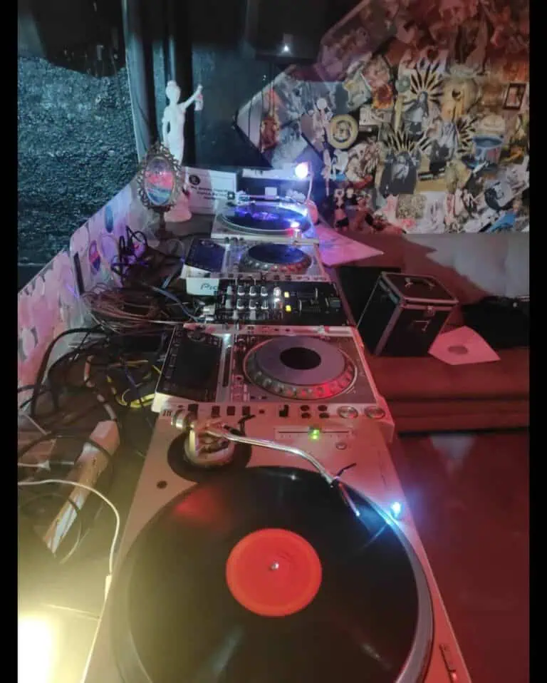 DJ-Konsole und Soundequipment bei einer Veranstaltung, ideal für Partys und Events mit professionellem Musik- und Unterhaltungsservice, in einem Ambiente, das mit Wandmalereien und Vintage-Accessoires dekoriert ist.