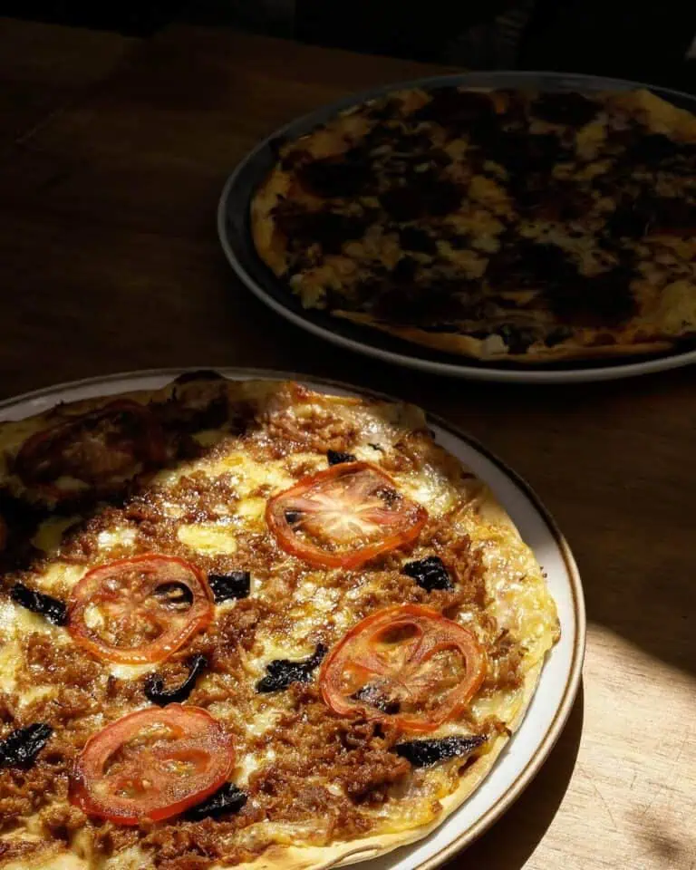 美味的披萨，配以番茄、牛肉碎和特制酱料，在氛围温馨的餐厅享用。是与伴侣或朋友在轻松舒适的环境中共享美食的理想之选。