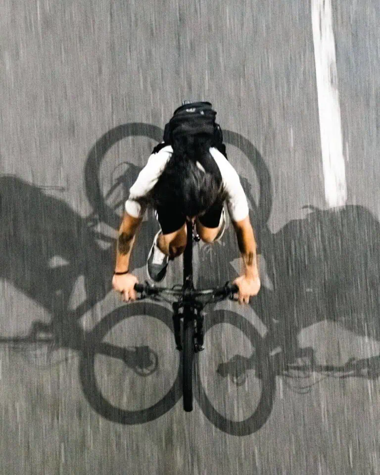 Cycliste en mouvement, prise de vue aérienne sur une route urbaine, montrant l'habileté et la passion du cyclisme dans un environnement urbain moderne.