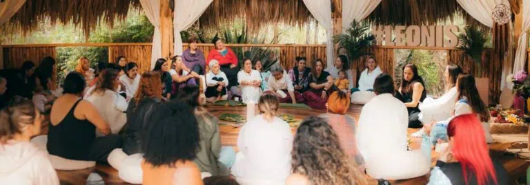 Women's gathering in a natural setting with rustic decor and a bohemian theme, promoting community and female empowerment. The event offers a welcoming environment for personal growth and networking.