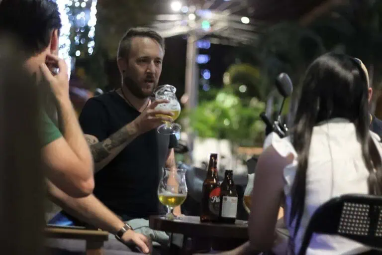 Craft Beer bei einer gesellschaftlichen Veranstaltung, Menschen unterhalten sich und amüsieren sich in einer nächtlichen Atmosphäre.