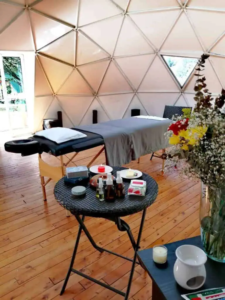 Soins relaxants, salle de massothérapie spa avec dôme géodésique confortable, centre de bien-être intérieur, parquet et lumière naturelle, parfait pour la détente et le rajeunissement.