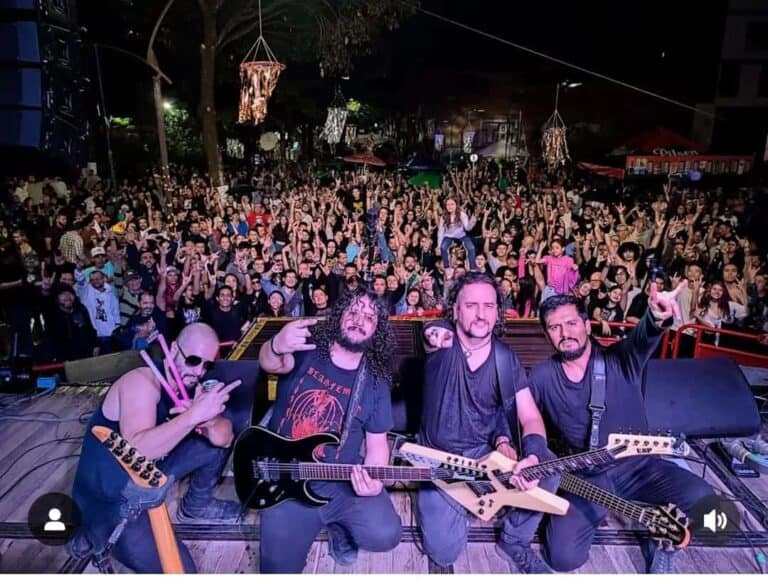 Disfruta de un concierto en vivo con una banda de rock en un evento nocturno al aire libre en Colombia, con una multitud entusiasta celebrando la música y la cultura local.
