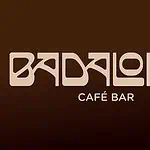 Disfrazado en el logotipo de Badalona Café Bar, con fondo marrón, foco en la identidad visual del establecimiento y ambiente de cafetería moderna.