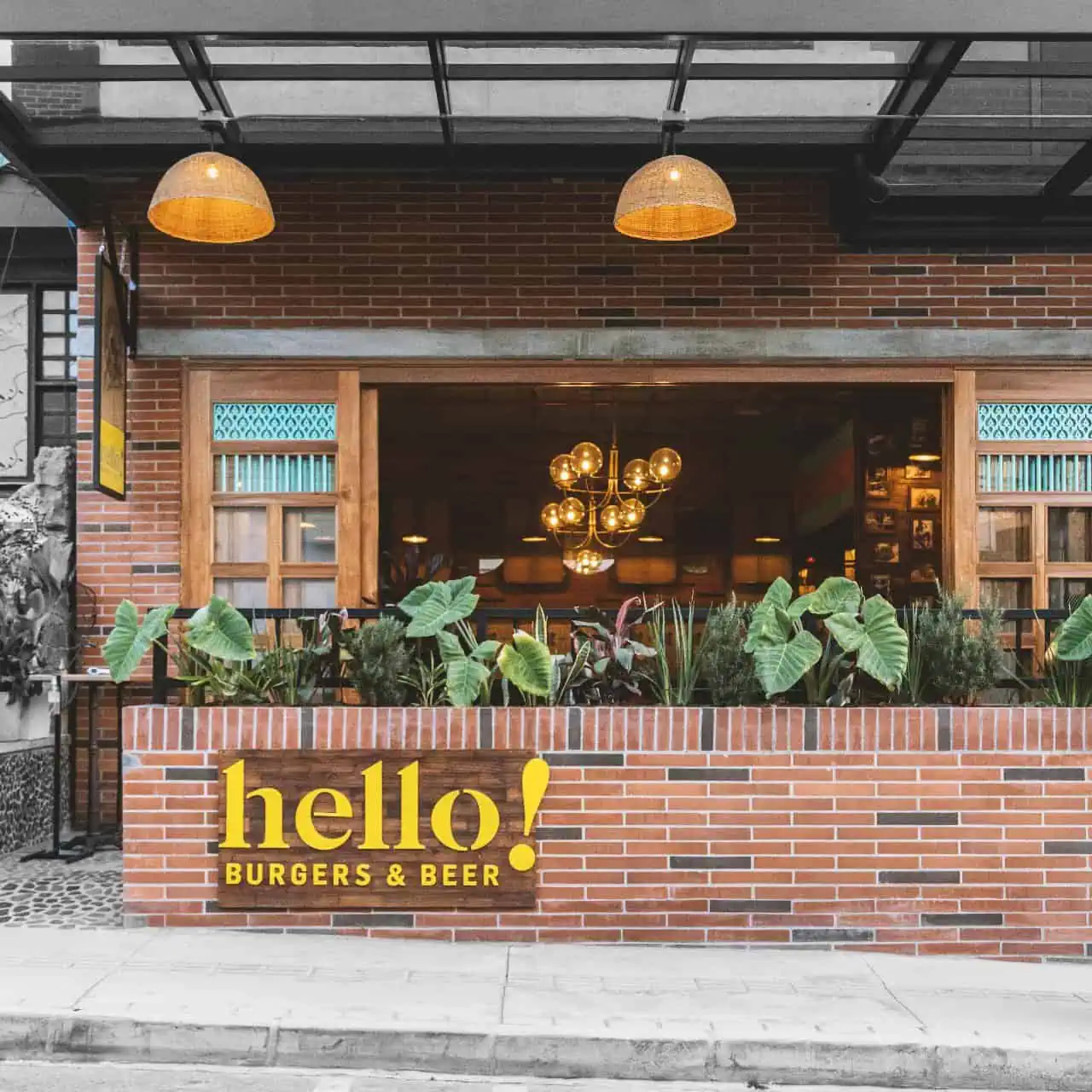 Restaurant proposant des plats servis sur une terrasse extérieure agrémentée de plantes et d'une décoration moderne. Un design chaleureux, idéal pour les événements et les rencontres. Photos pour promouvoir les espaces événementiels et la gastronomie de Bogotá.