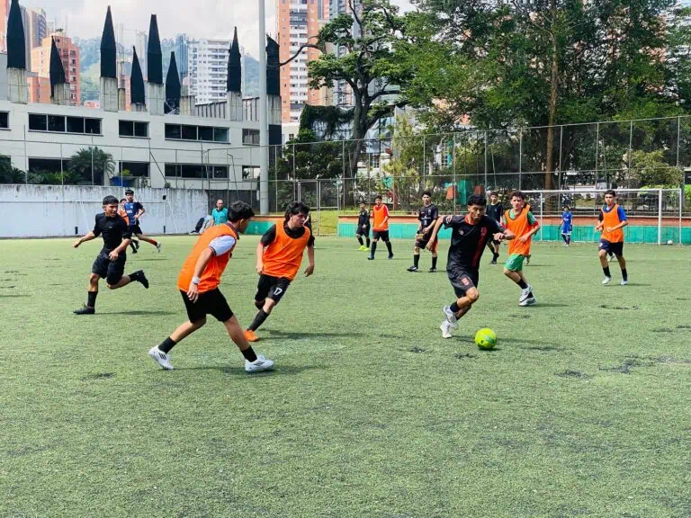 Jeunes joueurs s'entraînant sur un terrain en gazon synthétique en milieu urbain, participant à un tournoi ou à une pratique sportive en extérieur, promouvant des événements sportifs et des activités physiques.