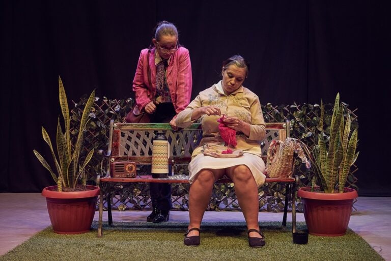 Bellas mujeres en escena de teatro con plantas decorativas y accesorios vintage.