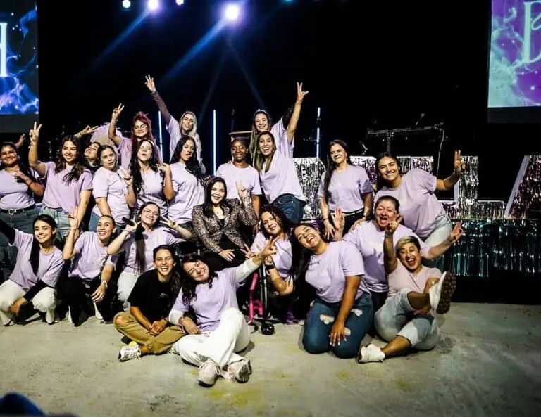 一群年轻人正在参加由……组织的公司活动。 Eventario 在一个配备现代灯光和数字屏幕的舞台上。