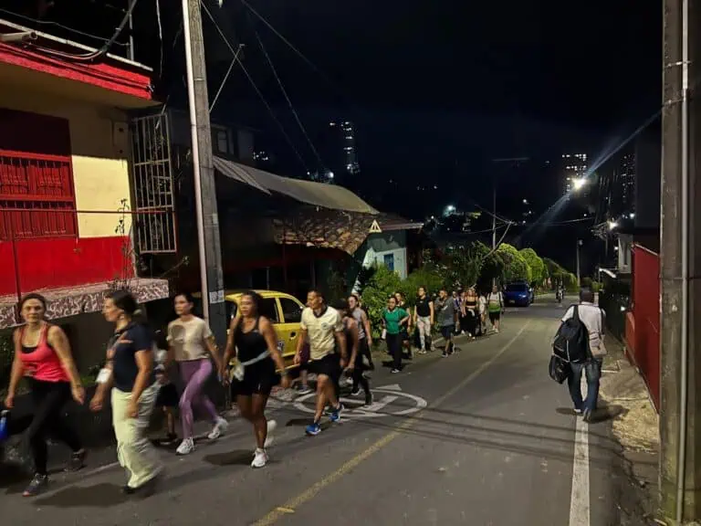 Événements nocturnes en Colombie, groupe de personnes marchant dans les rues urbaines, atmosphère informelle, communauté participative, vie quotidienne, éclairage urbain, photographie communautaire, vie de rue.