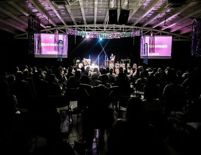 人们在设有舞台、屏幕和炫目灯光的礼堂参加活动，出席由……组织的会议或演讲。 Eventario.