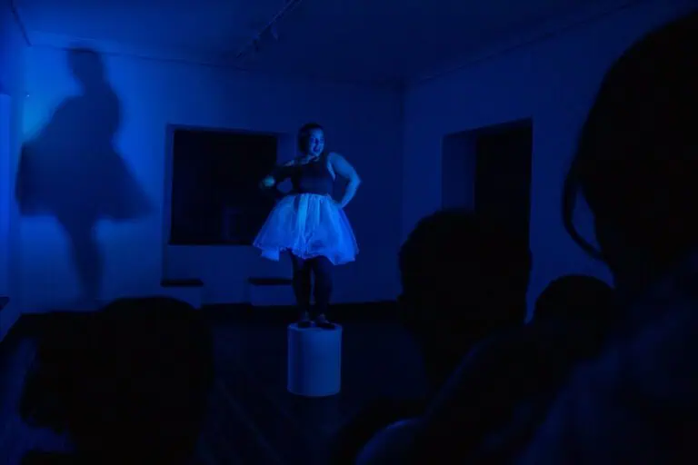 Danseur dans un spectacle de danse contemporaine sur une scène sombre avec un éclairage bleu, présentant une performance artistique pour des événements culturels et artistiques.