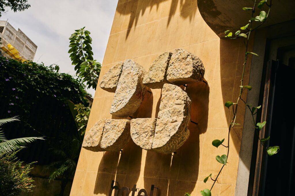 - Piedra decorativa en fachada de hotel, elemento arquitectónico moderno y natural, ideal para espacios con estilo contemporáneo y ambientalmente sustentable.