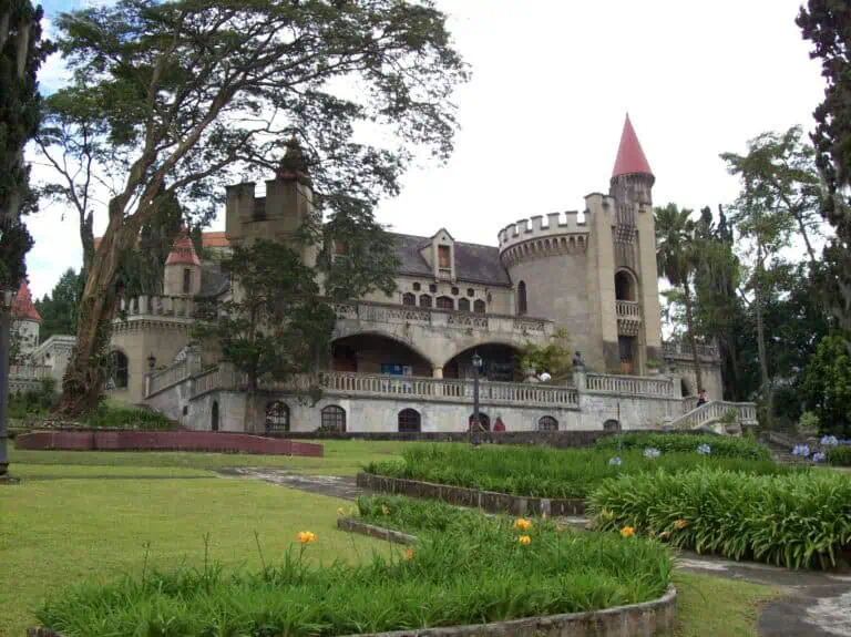 Ein Schloss im europäischen Stil in einem grünen Park mit Blumengärten und großen Bäumen, perfekt für Veranstaltungen und Feiern im Freien in Kolumbien.
