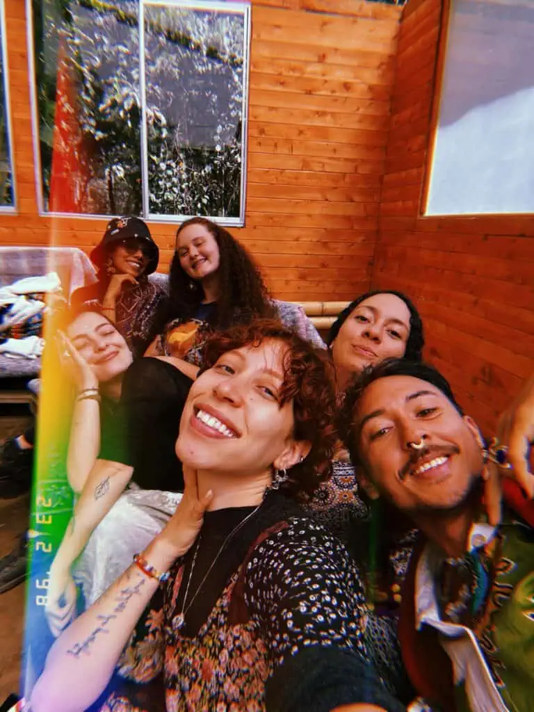 Friends smiling and posing together in a wooden interior, capturing a joyful moment at a social gathering, with a warm and friendly atmosphere, ideal for event and community content.