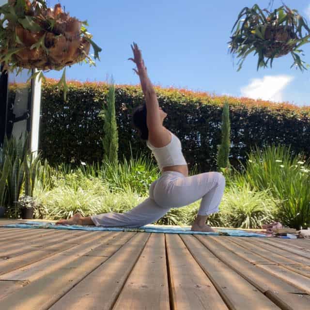 Yoga en jardín al aire libre con mujer en postura de estiramiento y tranquilidad para eventos y bienestar.