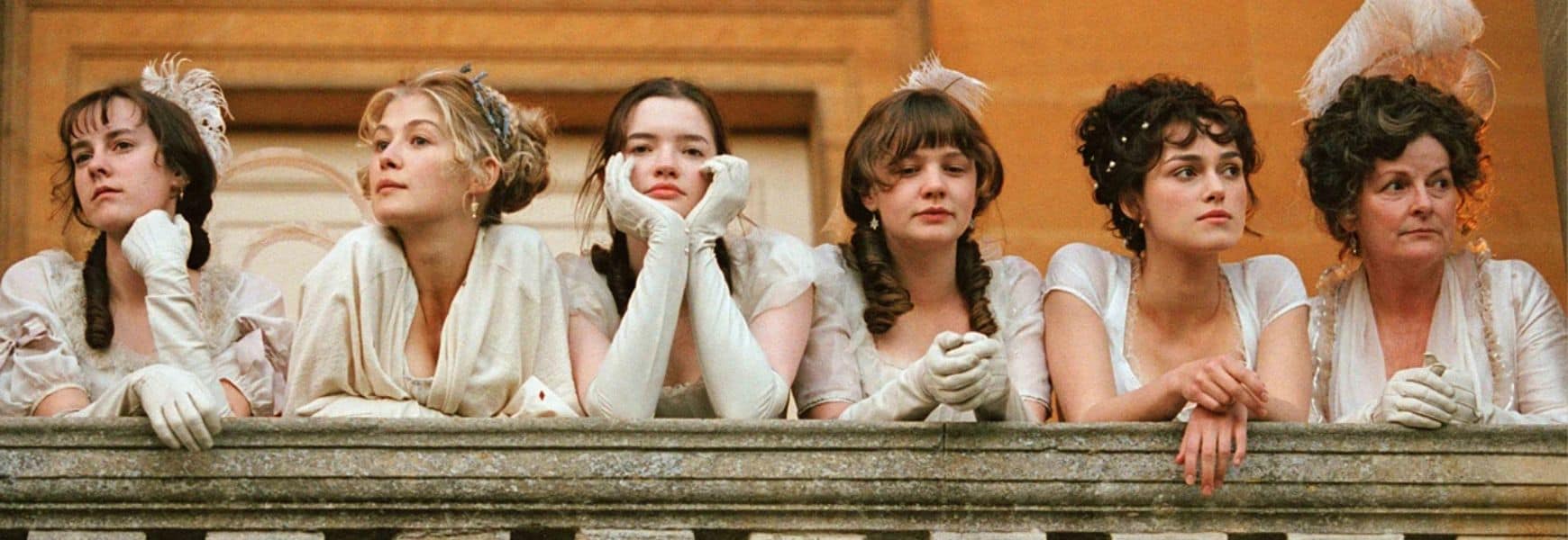 Chicas en vestuario clásico en un evento teatral, con un estilo vintage y elegantemente vestidas en un escenario de madera, simbolizando un momento histórico o cultural.