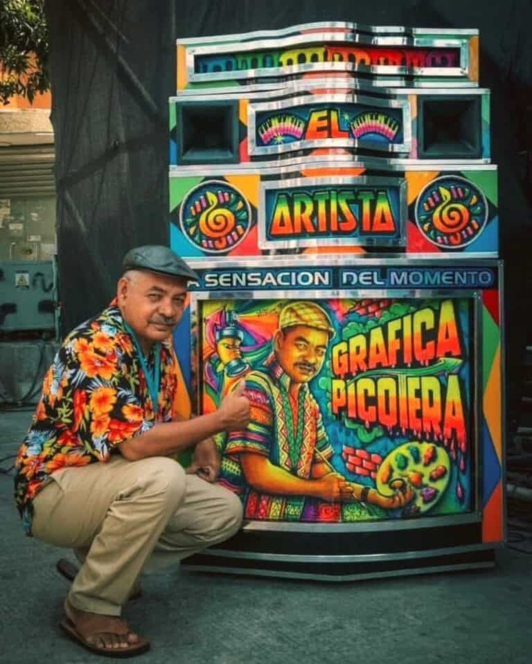 Colaborador posando junto a un graffiti artístico en un puesto de arte urbano, exhibiendo colores vibrantes y letras llamativas, destacando la creatividad y el talento en grafiti y arte callejero en Colombia.