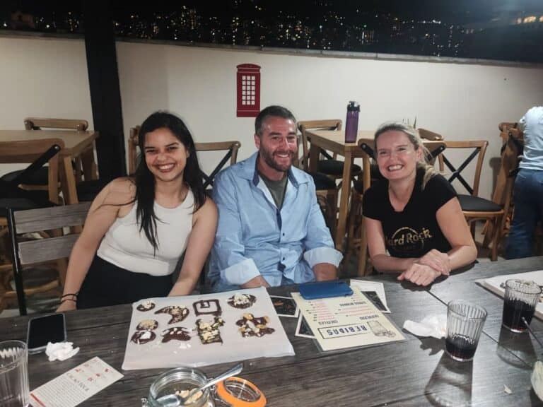 Disfrutando una celebración en un evento social con amigos en un restaurante con vista a la ciudad de noche.