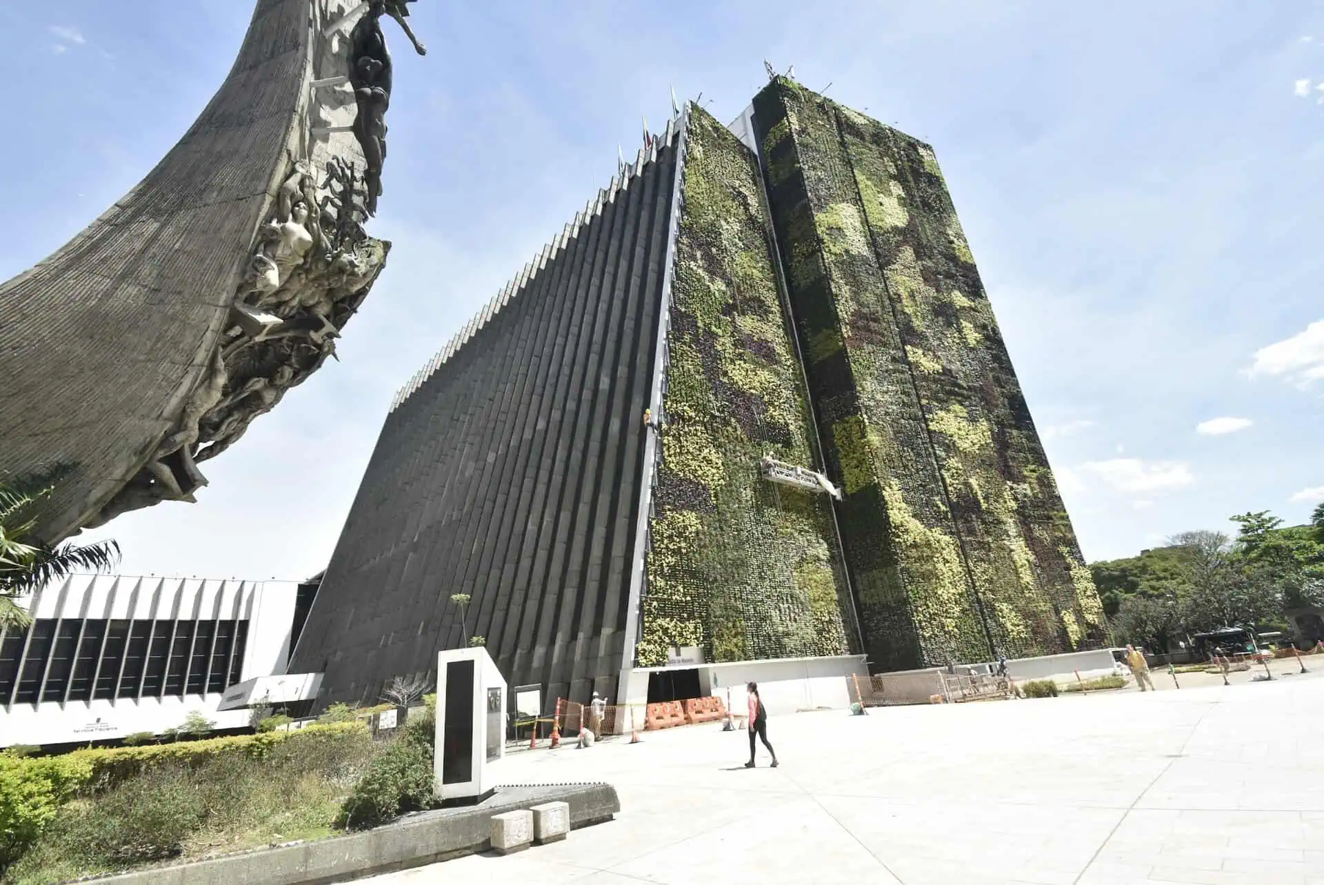 哥伦比亚波哥大一座现代建筑，其绿色外墙由植物和艺术雕塑构成，位于公共空间内。