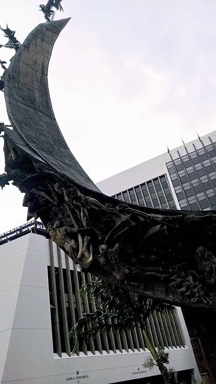 Bóveda de proa de un barco en la ciudad con edificios modernos en el fondo, con árboles y cielo despejado. Museo cubano, arquitectura patrimonial, monumento histórico y elementos culturales destacados.