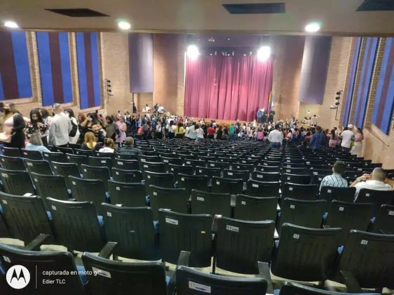 Sièges et scène dans un auditorium pour événements et réunions d'affaires à Bogotá, avec une capacité pour de grands groupes et équipé d'une technologie moderne pour des conférences et des présentations.