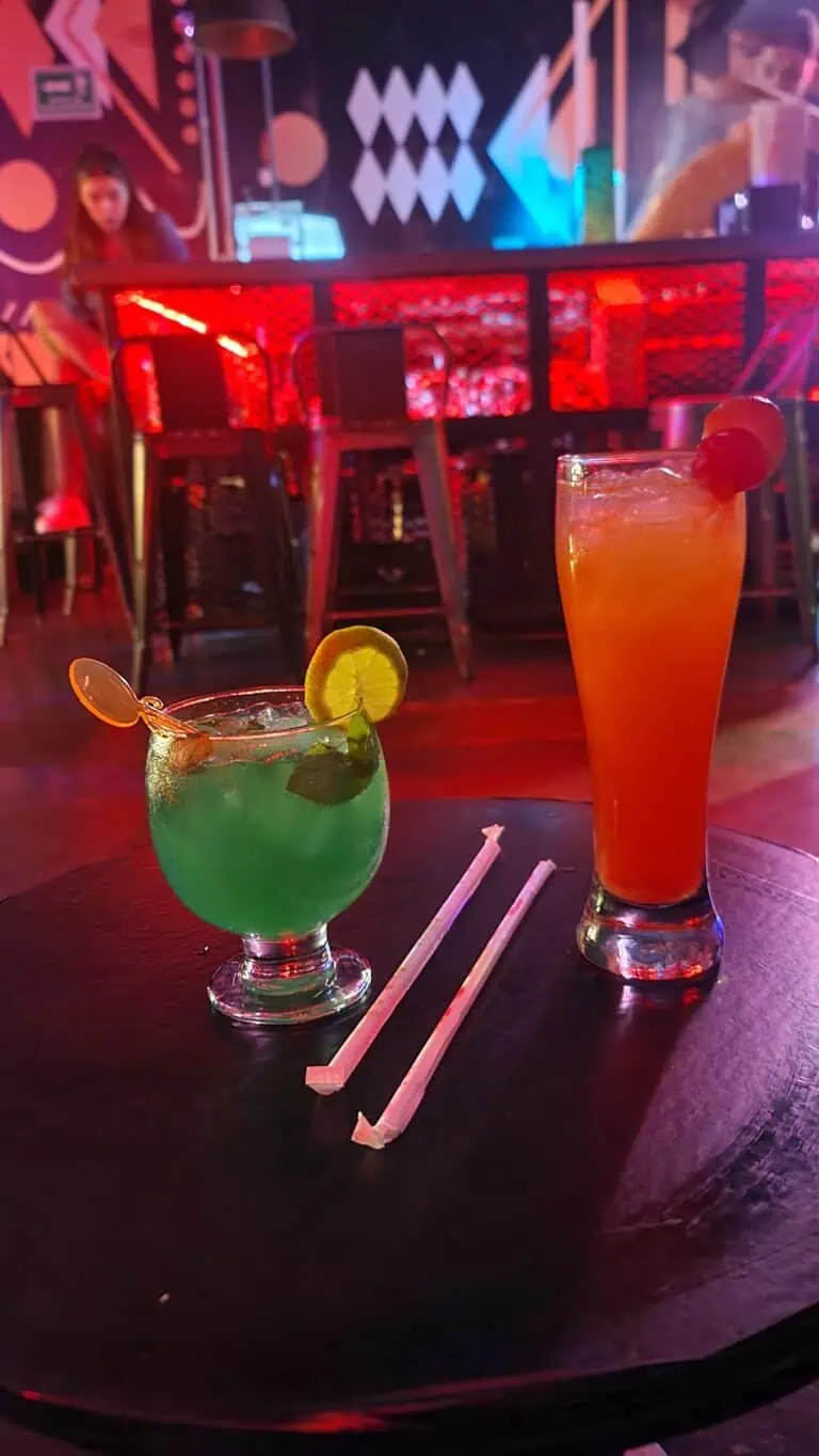 Colorful cocktails in a bar with a modern and vibrant atmosphere, ideal for events and parties, in a venue with striking decor and live music.