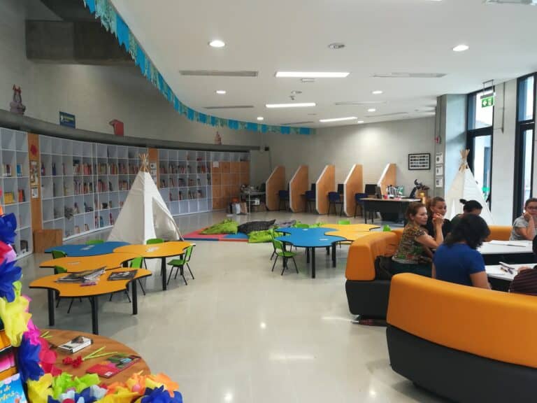 Colorida área infantil en un espacio moderno y luminoso, ideal para eventos y reuniones con actividades para niños, con zonas de lectura, juegos y decoración temática.