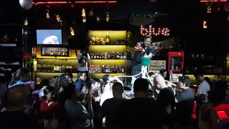 Barra de bar moderna con evento en vivo y espectáculo de bartender en un restaurante nocturno en Bogotá, Colombia.