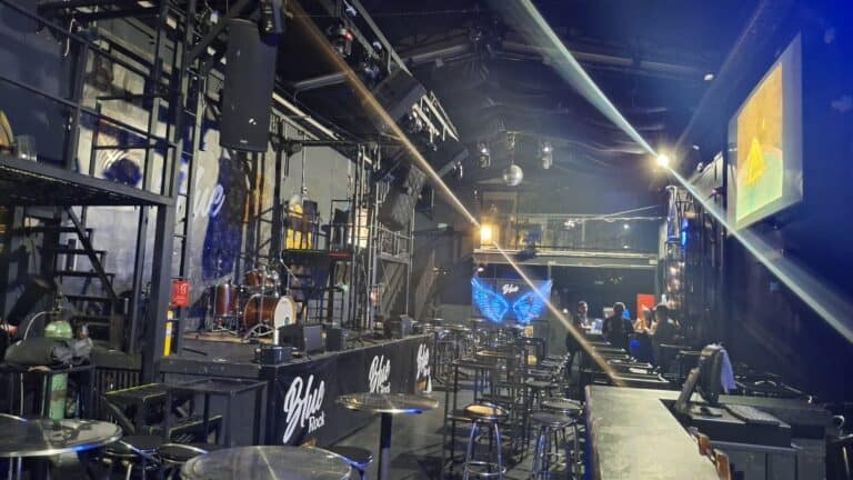 Una sala de eventos y conciertos con escenario equipado con instrumentos musicales, sistemas de sonido, pantallas y luces para presentaciones en vivo y eventos culturales.