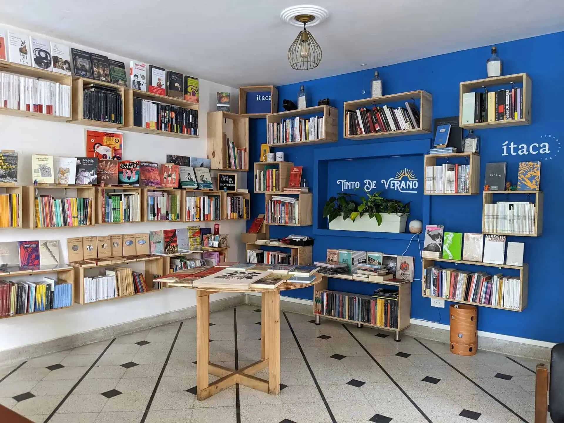 Une bibliothèque avec des étagères remplies de livres de différentes couleurs et tailles, une décoration moderne et une atmosphère accueillante dans un espace culturel à Itaca.