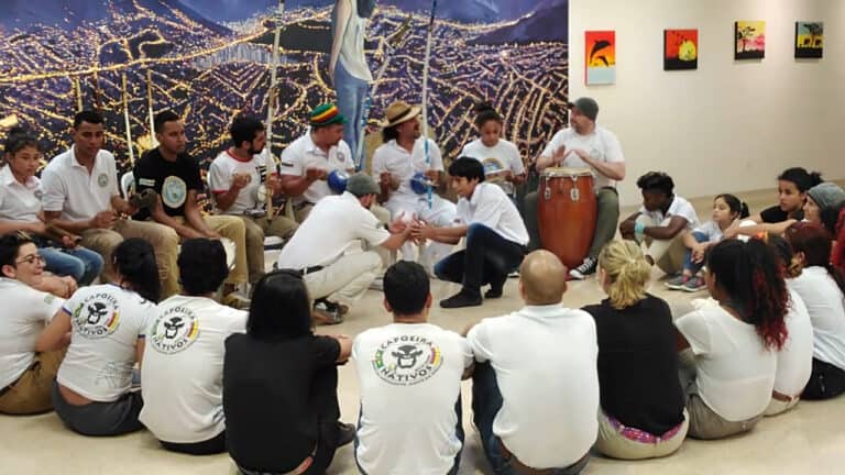 Eventario, evento comunitario con música en vivo y actividades culturales, participación juvenil, celebración cultural en espacio cerrado, ambiente festivo y dinámico, intercambio cultural y diversión.