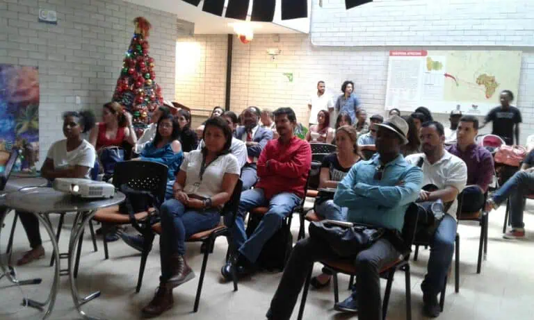 Publikum bei einer Schulungsveranstaltung oder Konferenz in einem weihnachtlich geschmückten Gebäude in Kolumbien.
