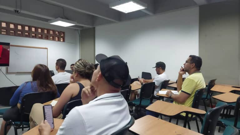 Asistencia a taller o seminario en aula moderna con estudiantes atentos y usando tecnología para aprendizaje.