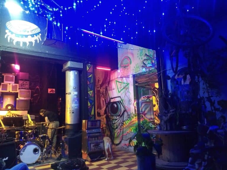 - Vibrante ambiente de bar con decoración de arte urbano, luces de neón y música en vivo, ideal para eventos y reuniones sociales en un espacio artístico y moderno en Bogotá.