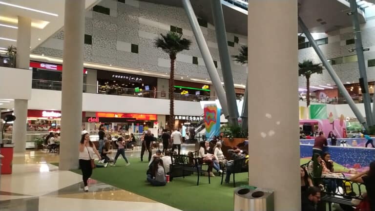 Centro comercial con áreas de descanso y entretenimiento, tiendas modernas y una zona de juegos para niños en un ambiente familiar y dinámico en Colombia.