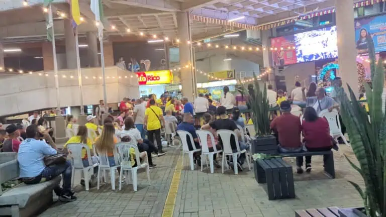 Ein fantastisches Event in einem Einkaufszentrum, bei dem sich viele Menschen zu einer Feier versammelt hatten, umgeben von Lichtern, Food Courts und digitalen Bildschirmen, ein Beispiel für Eventplanung und digitales Marketing in Kolumbien.