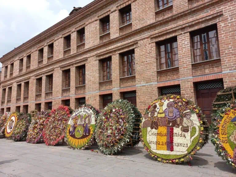 在哥伦比亚的一次文化庆典上，人们在砖砌建筑的外墙上摆放鲜花以示敬意和献花。